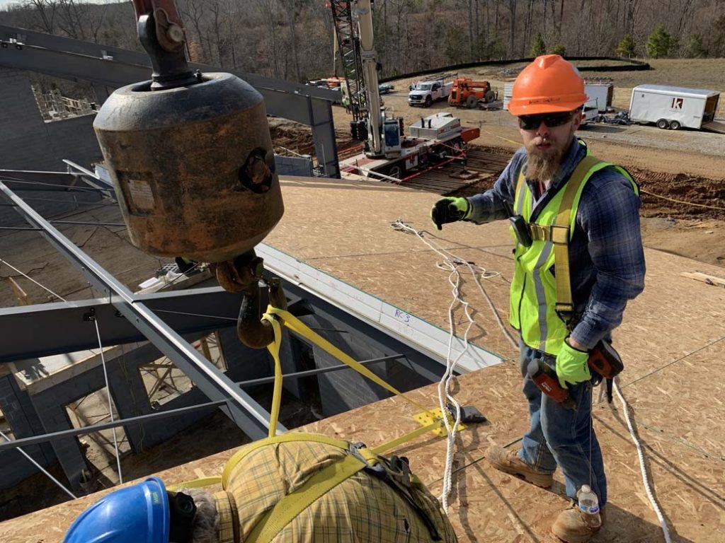 commercial construction crew installing structural insulated panels on a roof